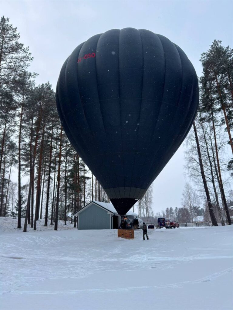 Melnais balons YL-050 ziemā starp priedēm